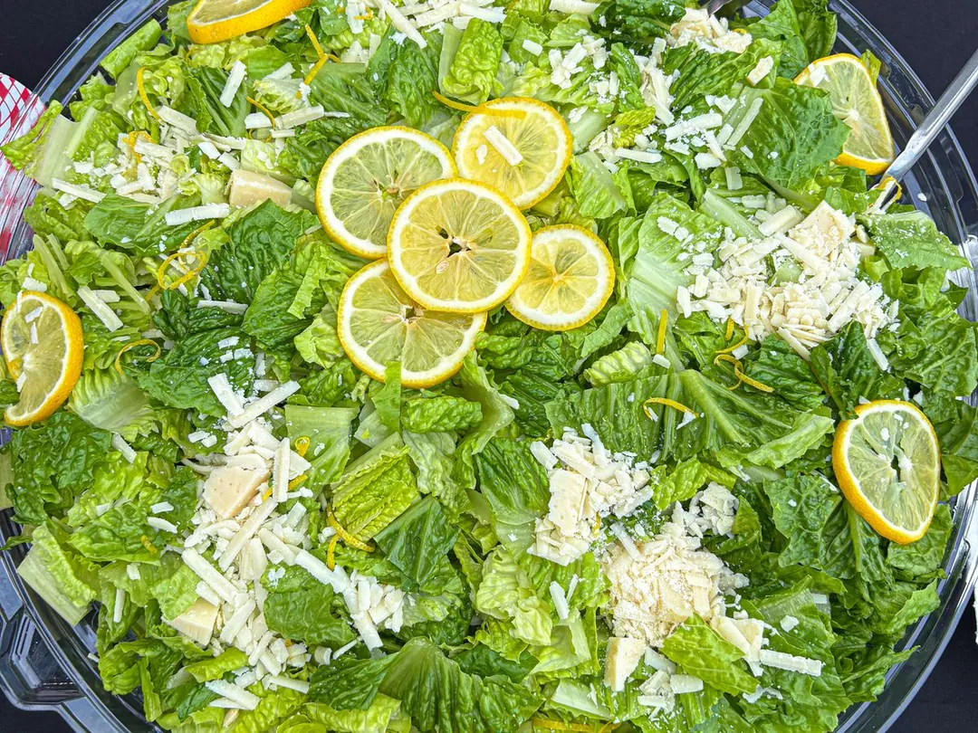 Sum Pig Caesar salad with shaved parmesan and lemon over organic romaine